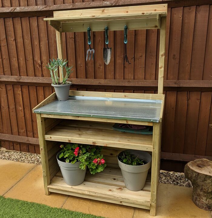 Wooden gardening bench with tools and potted plants; perfect for funny wholesome anniversary surprises.