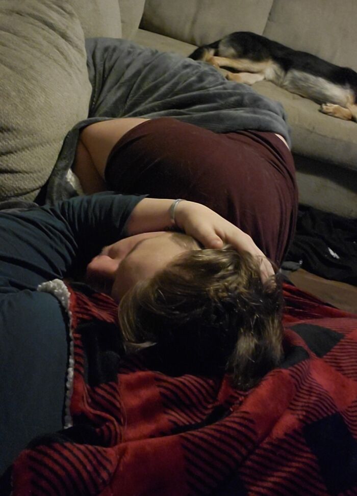 Person snuggling on a couch with a dog in the background, exemplifying love in long-distance relationships.