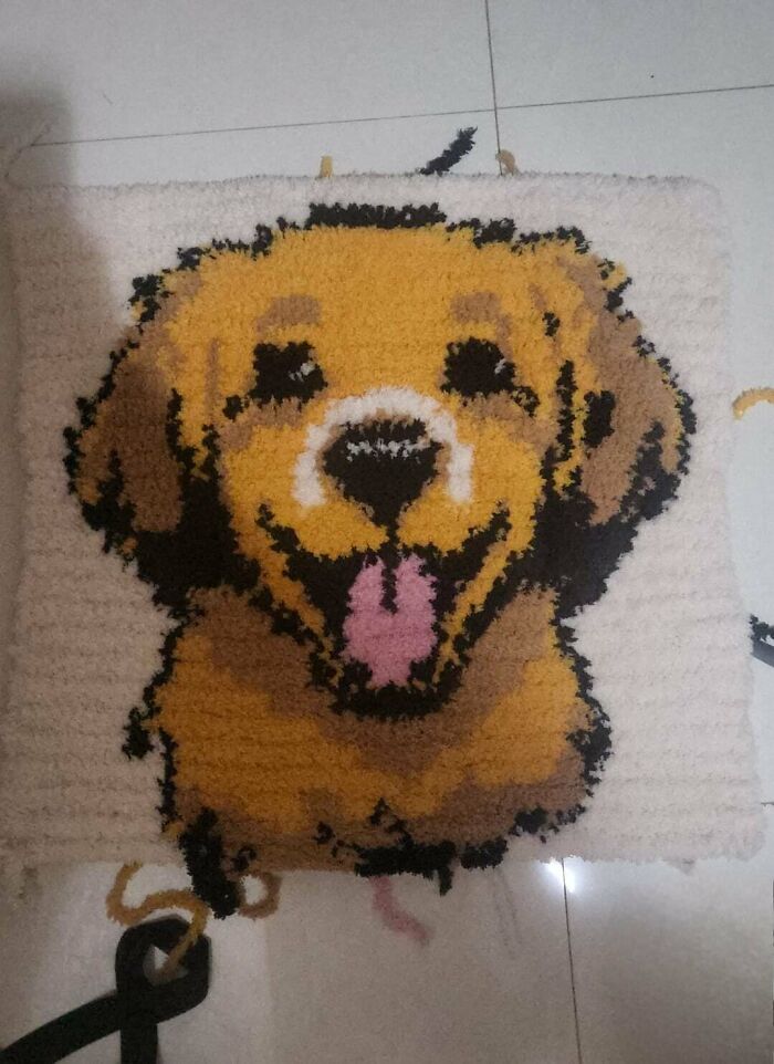 Crochet project featuring a detailed and colorful smiling dog face made by a proud crochet enthusiast.