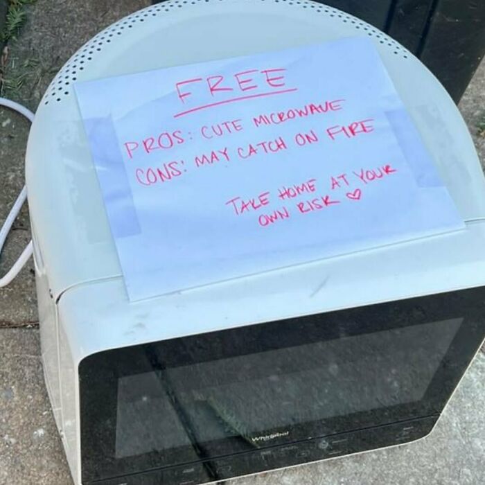 Microwave labeled free on NYC curb with note about risks, part of ‘Stooping NYC’ treasures.