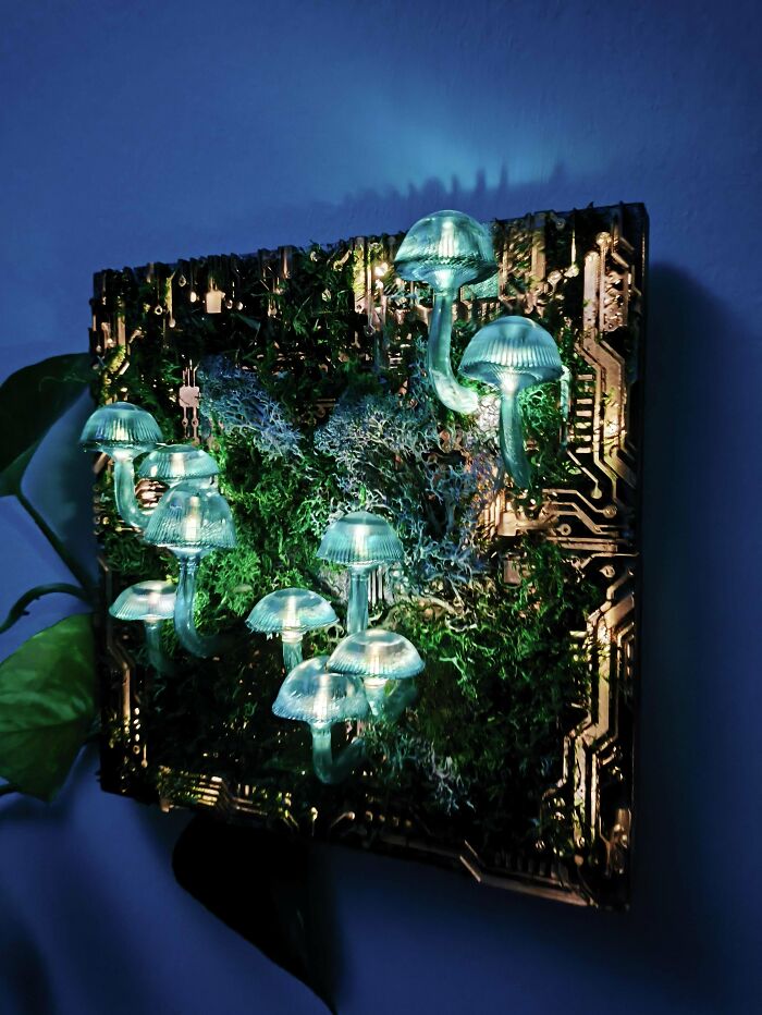 Glowing mushroom DIY project with circuitry and greenery on a wall decor.