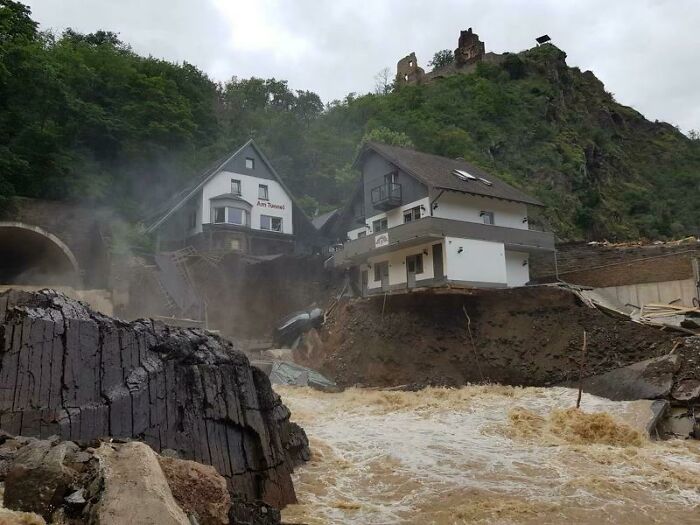 Houses damaged by floodwaters showing nature disaster resilience amidst landslide and debris.