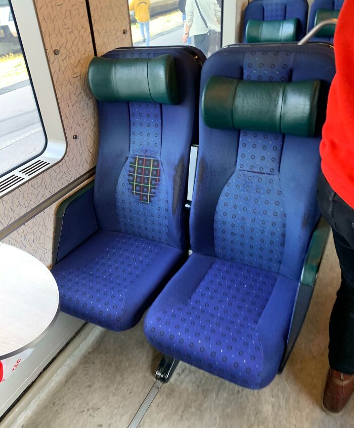 Worn-down blue train seats with visible fabric deterioration showing the effects of time.