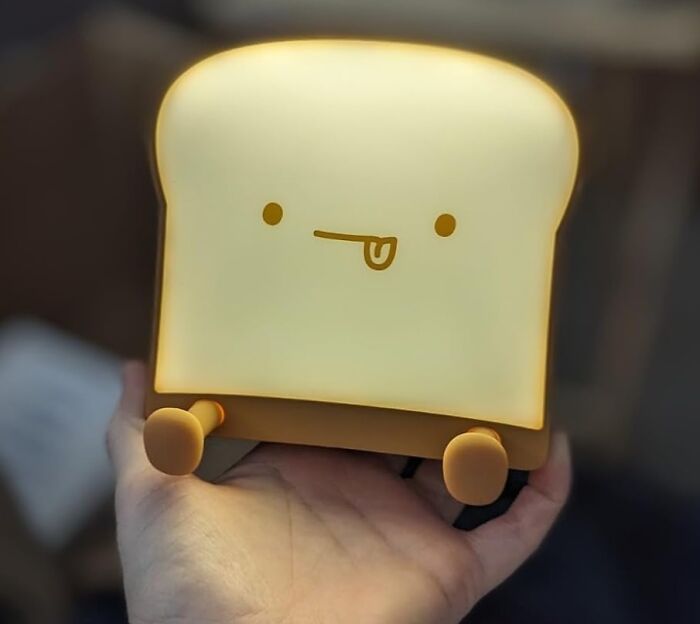 A cute toast-shaped nightlight, a hottest new Amazon release, held in a person's hand.