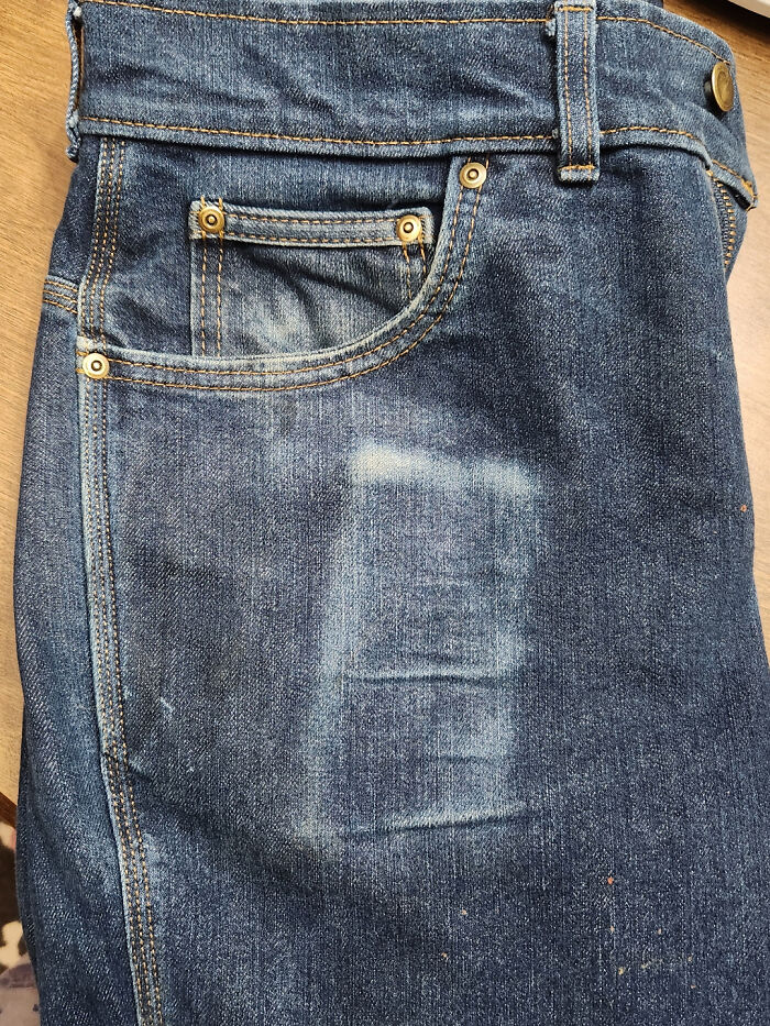 Worn denim jeans with faded areas near the pocket, illustrating how time affects fabric.