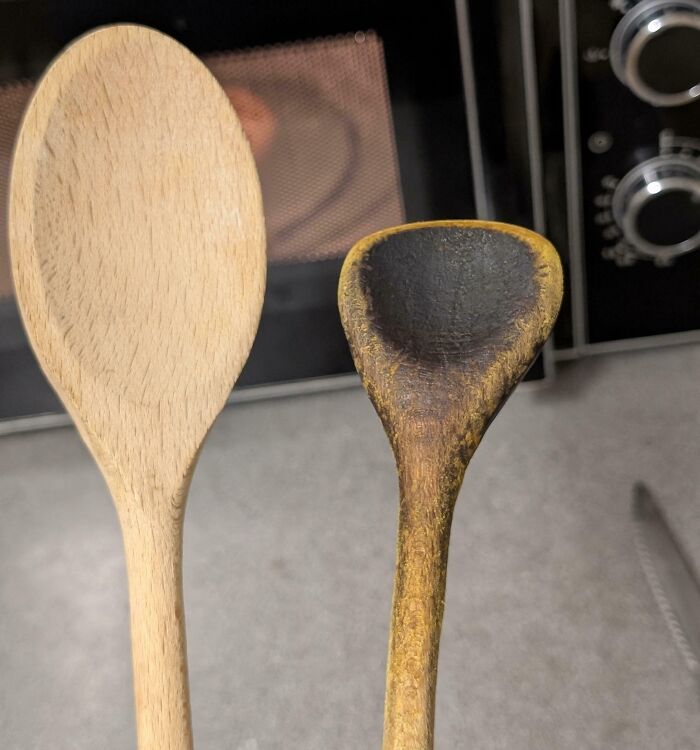 Worn-down wooden spoons show the effects of time and use, with one spoon visibly darker and more eroded than the other.
