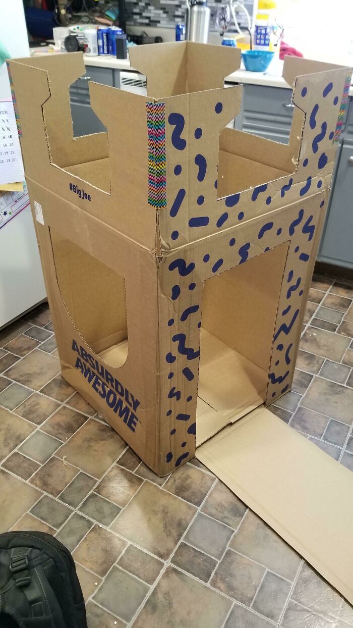 Cardboard box castle labeled "Absolutely Awesome" showcasing cool product surprises in a kitchen setting.