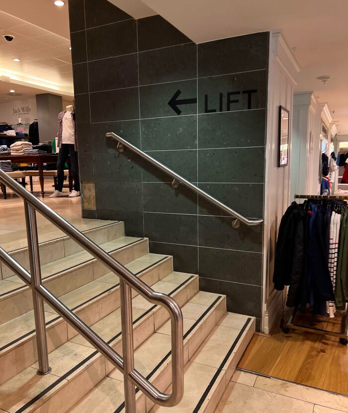 Stairs leading to a wall labeled "Lift" in a clothing store, showcasing unfortunate interior design.