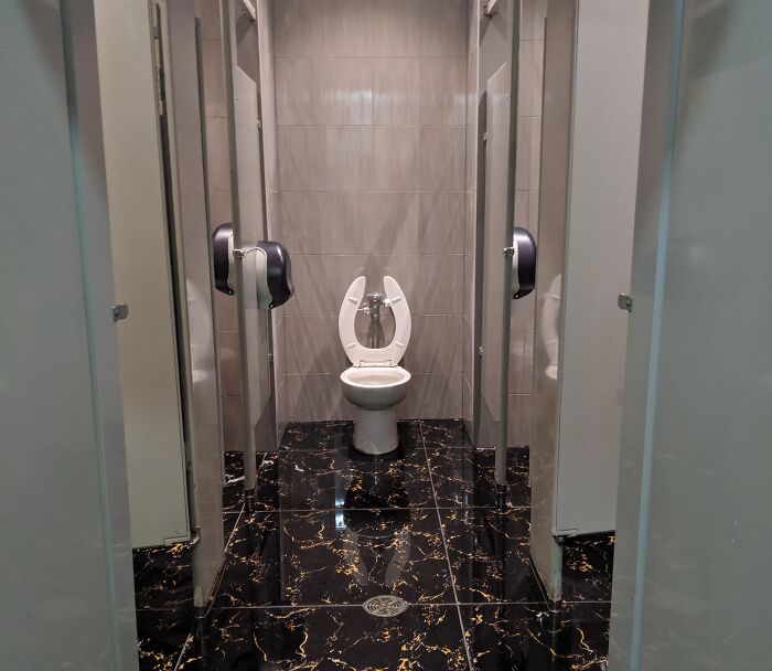 Public restroom with open stalls and poor design choices, showcasing unfortunate interior layouts.