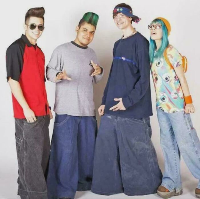 Group of friends in ’90s fashion, wearing baggy jeans and colorful outfits, reminiscing about the wild 1990s style.