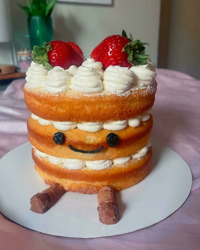 Cute culinary cake creation with layers, strawberry toppings, and a smiley face, showcasing baking creativity at its finest.