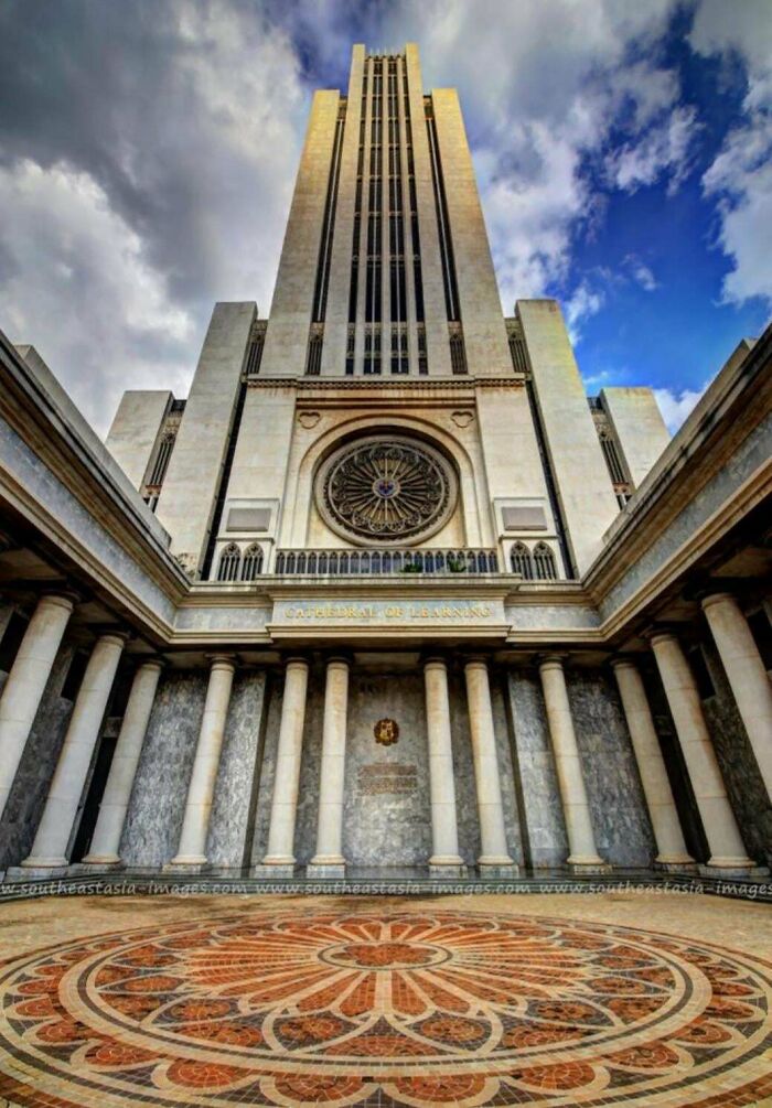 Tall imposing building with gothic architecture and columns under a cloudy sky, evoking supervillain headquarters aura.