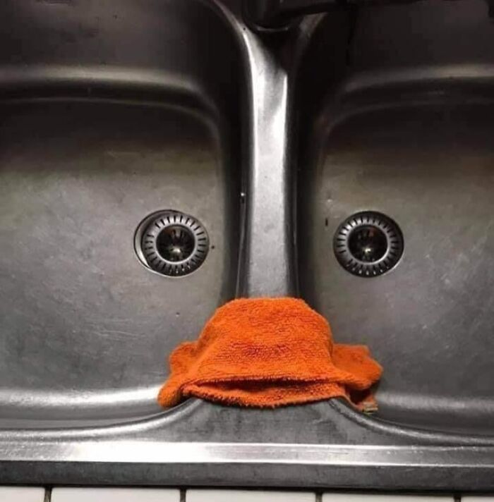 Pareidolia-Pictures: A face-like image formed by sink drains and an orange cloth resembling a nose.