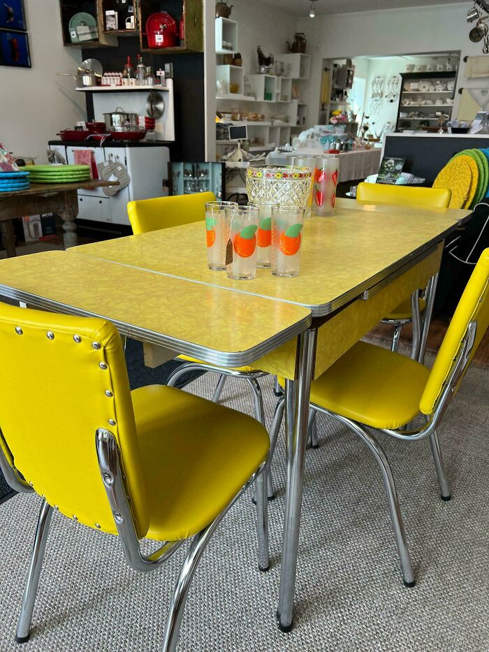 Vintage yellow kitchen table set with retro glasses and mid-century decor in a nostalgic home setting.