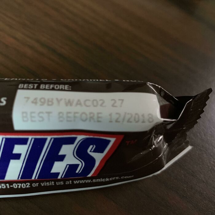 Expired candy bar gifted by the company, showing "Best Before 12/2018" date on the wrapper.