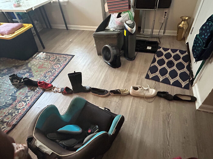 Niño crea fila con zapatos en la sala, una de las tonterías divertidas que los pequeños comparten con sus padres.