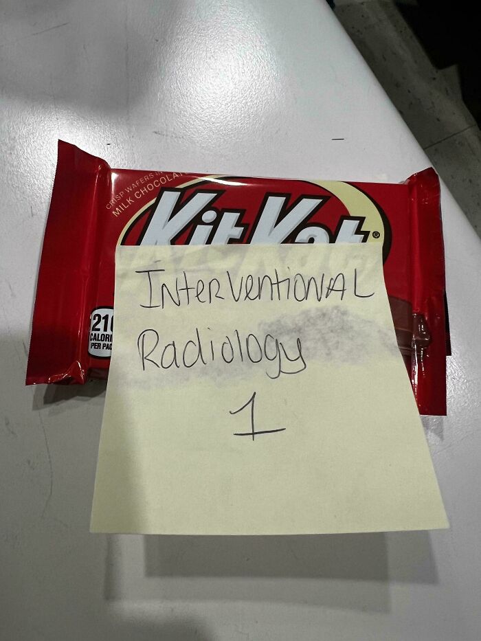 Kit Kat with a note reading "Interventional Radiology 1," illustrating infuriating company gifts bonuses.