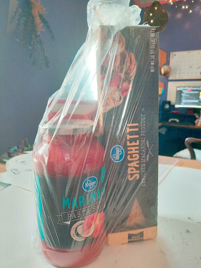 Jar of marinara sauce and spaghetti box wrapped together, resembling an infuriating company gift.
