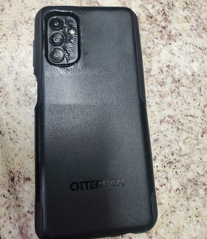 Smartphone in Otterbox case with smudged grime; confused mistake by user.