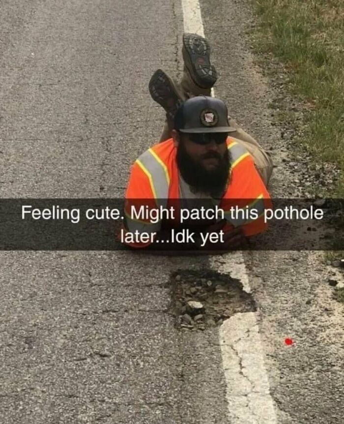 Man in reflective vest lying on road near pothole with caption about feeling cute and patching pothole later, weird internet pic.