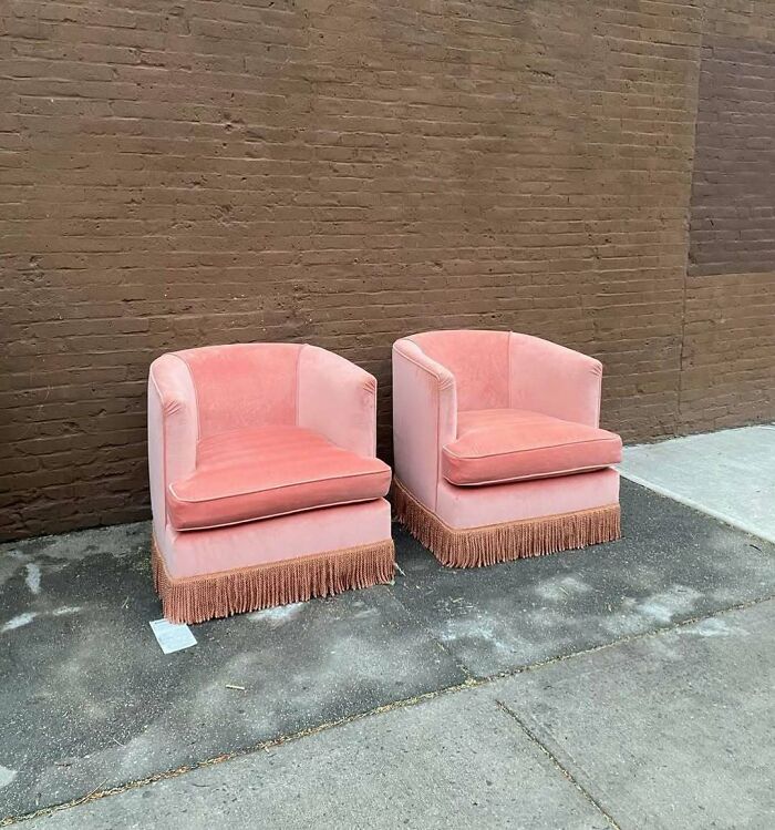 Pink velvet chairs with fringe left on NYC curb as street treasure for others to find.