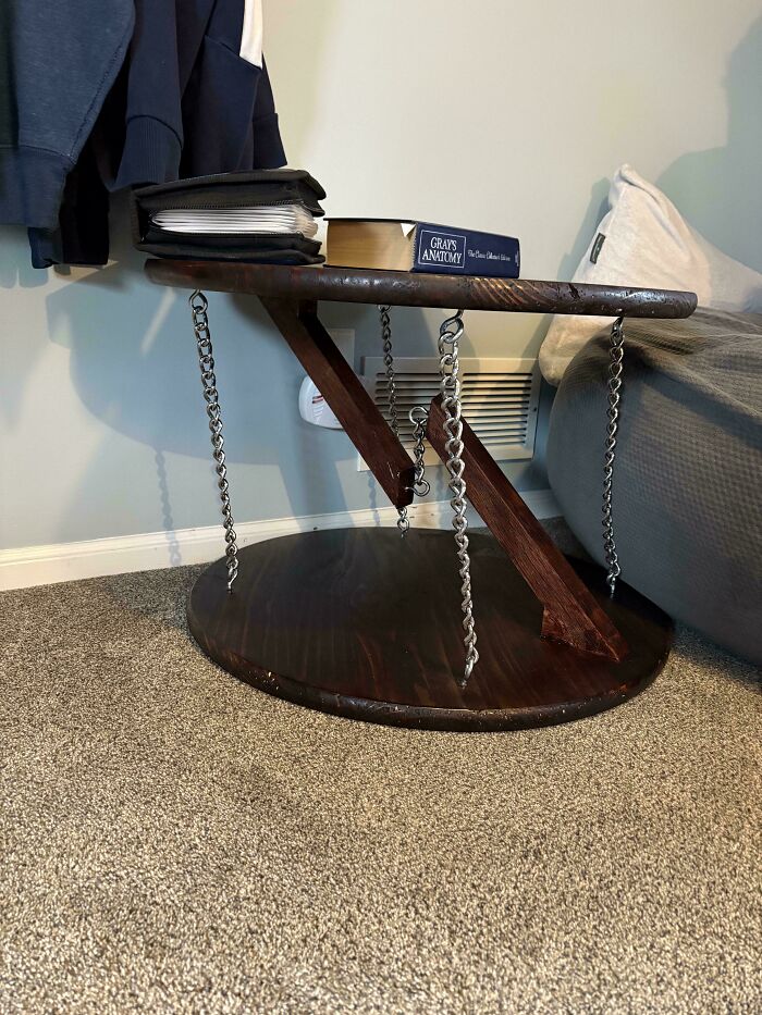 DIY project: A unique side table with chain support design, featuring books and folders in a cozy room setting.