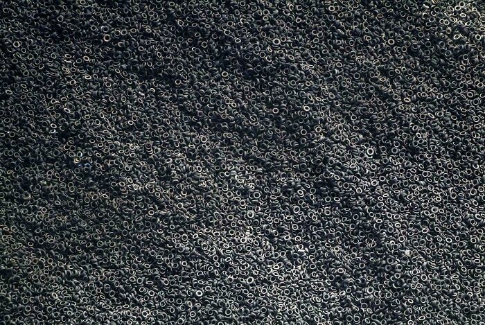 Aerial view of a vast pile of discarded tires, symbolizing consumerism waste.