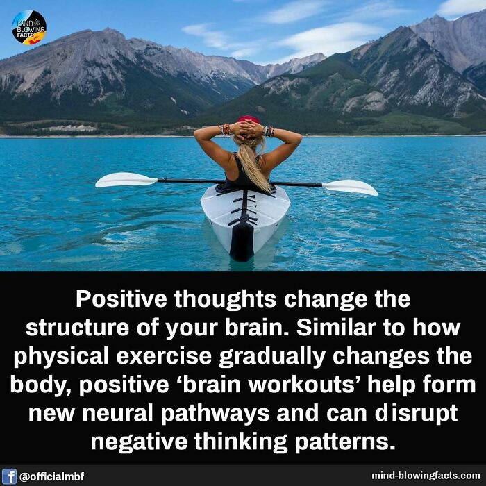 Woman kayaking on blue lake with mountains, illustrating mind-blowing facts about positive thinking and brain workouts.