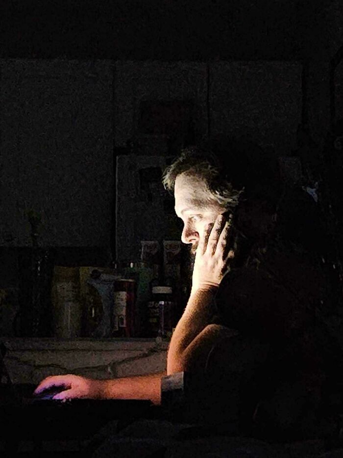 Person lit by screen glow in dark room, evoking an accidental Renaissance painting with dramatic contrast.