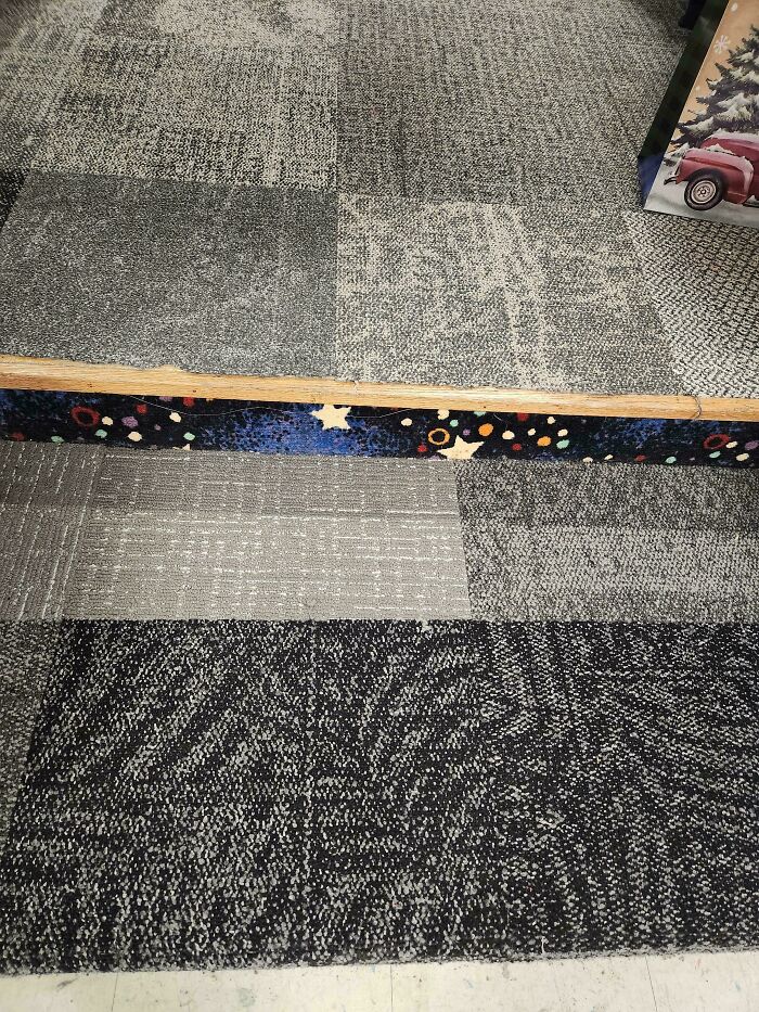 Patterned carpet reminiscent of wild '90s decor with multicolor accents on a step edge.