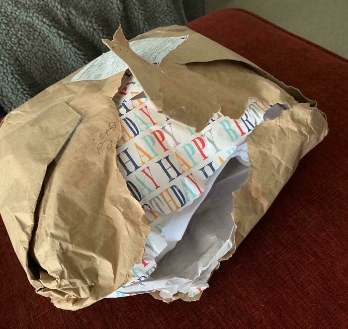 Damaged package with torn birthday wrapping, showcasing people being complete jerks by ruining gifts.
