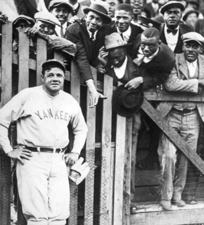 Baseball player in a Yankees uniform posing with fans, showcasing fascinating sports history.
