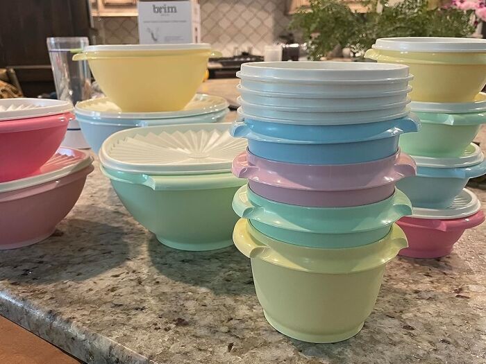 Stack of colorful retro storage bowls with lids on a kitchen countertop, vintage style for the old soul.