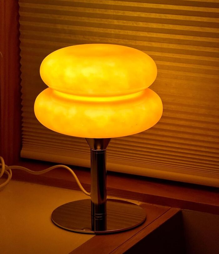 Retro finds old soul glowing orange vintage table lamp with chrome base on wooden surface by window blinds