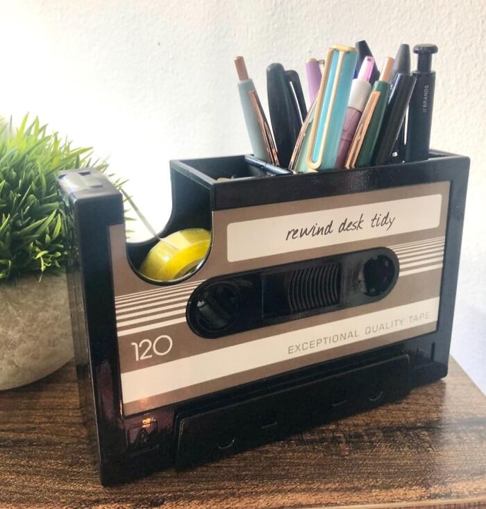 Cassette tape-shaped pen holder on desk with plants, capturing Retro Fever style.