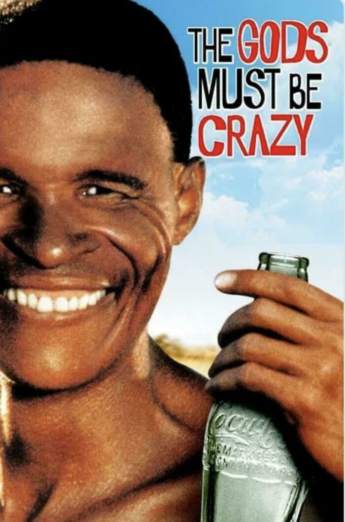 Smiling person holding a glass bottle from the movie "The Gods Must Be Crazy," evoking memories of childhood.