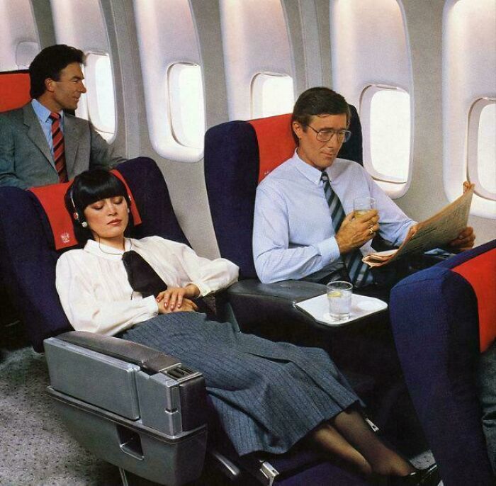 Passengers in vintage airplane seats reading and relaxing, evoking childhood memories of air travel in the past.