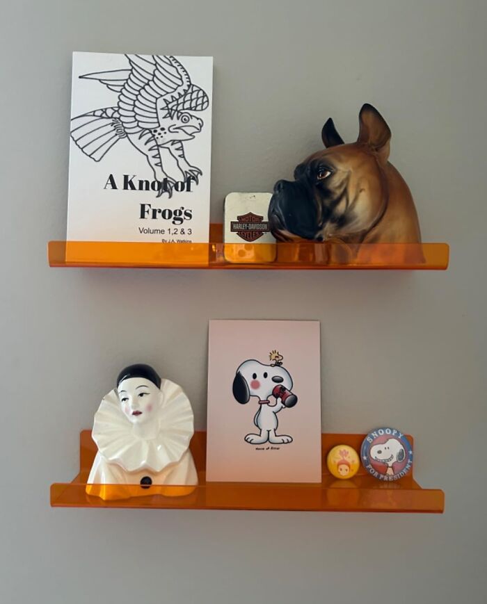 Retro finds on orange shelves including vintage book, dog sculpture, Snoopy card, and memorabilia for old soul decor.
