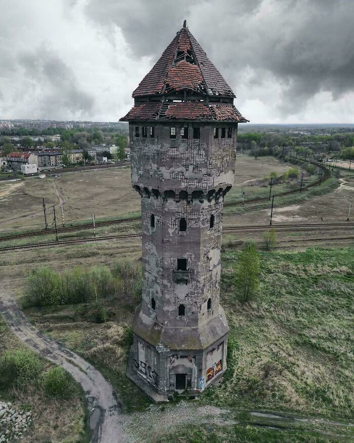Abandoned tower with a broken roof and c*****d walls, exuding an evil aura like a supervillain headquarters in gloomy surroundings.