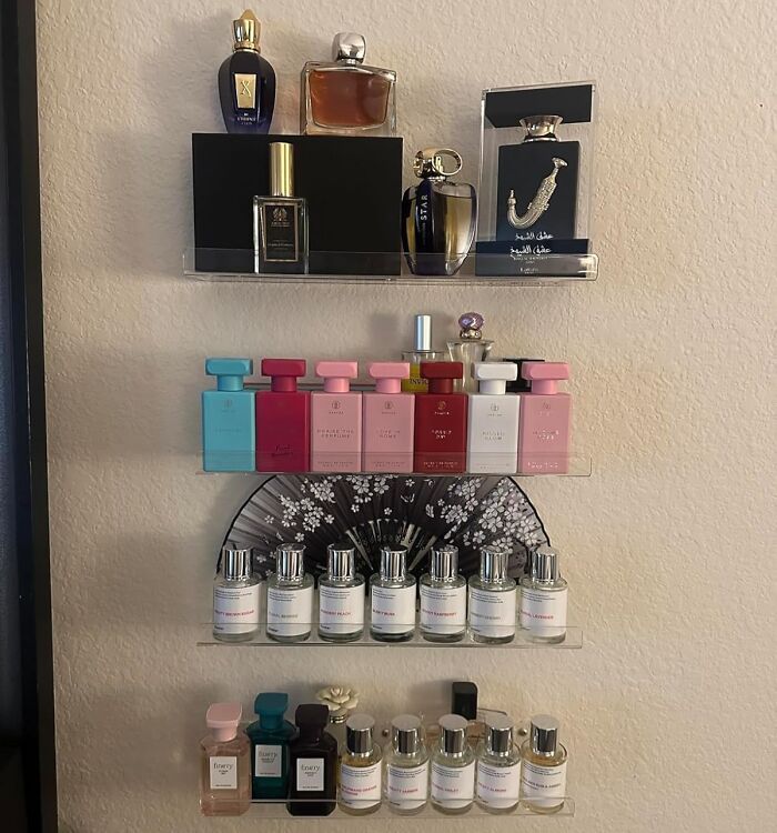 Perfume bottles neatly arranged on renter friendly wall-mounted shelves.