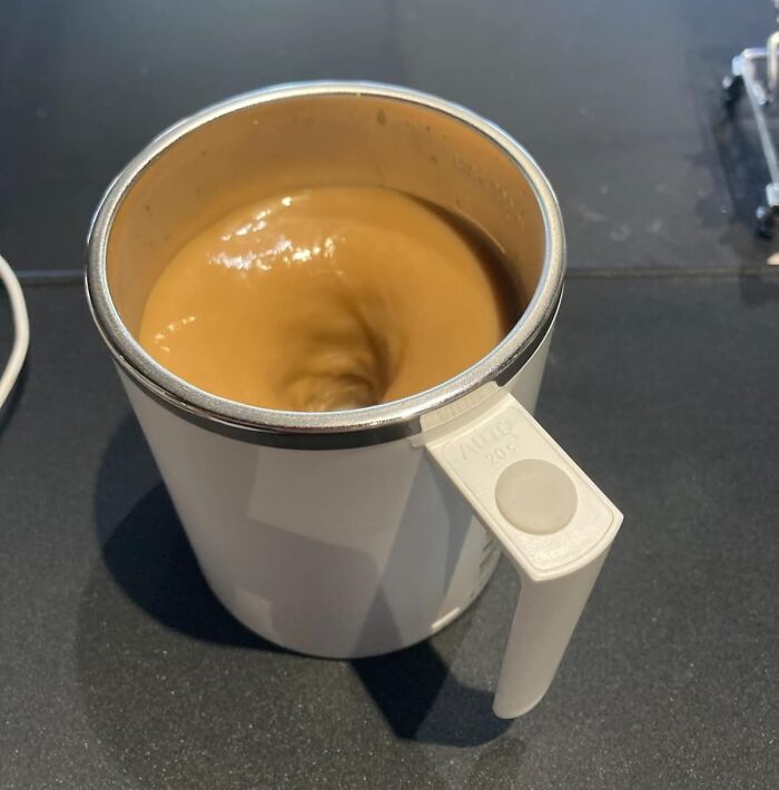 A self-stirring mug with coffee swirling, showcasing innovative tech finds.