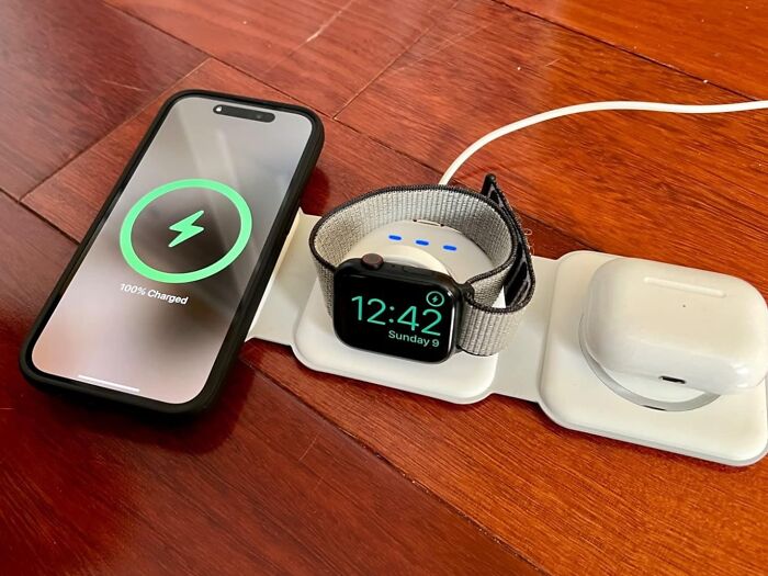 Smartphone, watch, and earbuds on a charging pad, showcasing cutting-edge tech finds in modern design.