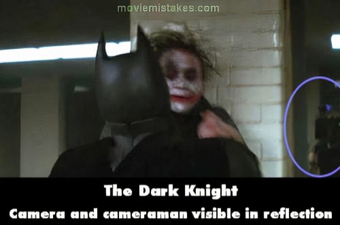 Movie scene error in The Dark Knight with a cameraman visible in the reflection. Funny movie mistakes.