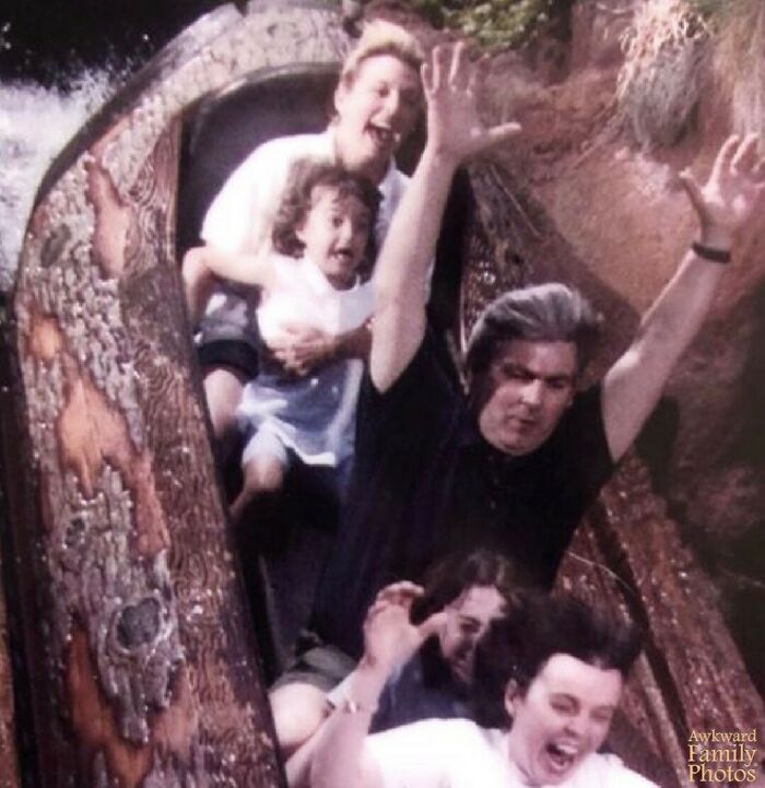 Family on a log ride showing mixed emotions, capturing an awkward family photo that also feels incredibly sweet.
