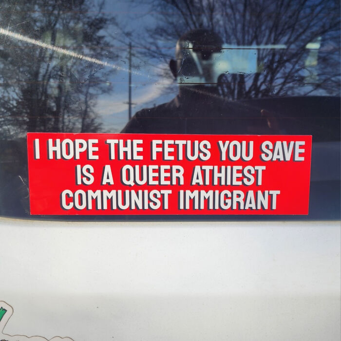 Funny bumper sticker with bold text on a car window.