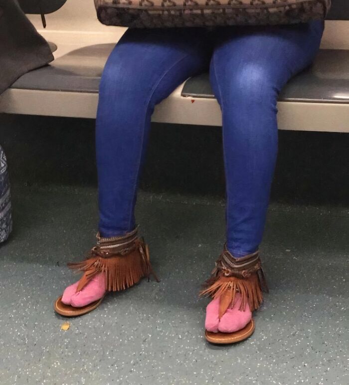 Passenger with unusual fringed sandals on a train, wearing blue jeans and holding a patterned bag.