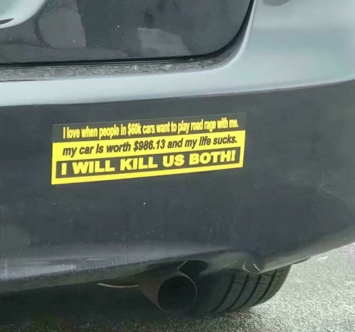Close-up of a car bumper with a funny bumper sticker about road rage and car value.