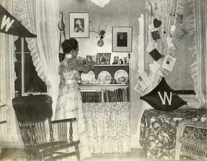 Woman arranging items in a vintage room, showcasing historical household decor and lifestyle from decades ago.