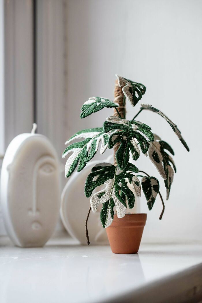 Embroidered green and white leaves crafted to resemble a potted plant showing incredible embroidery skills on display.