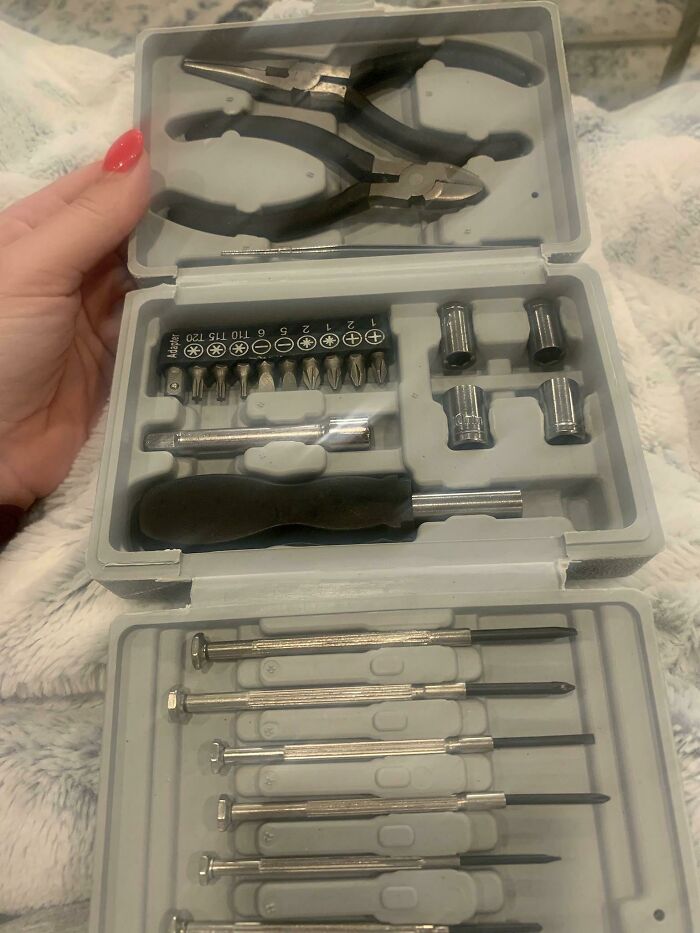 Toolset received as frustrating company gifts and bonuses, including pliers, screwdrivers, and various bits.